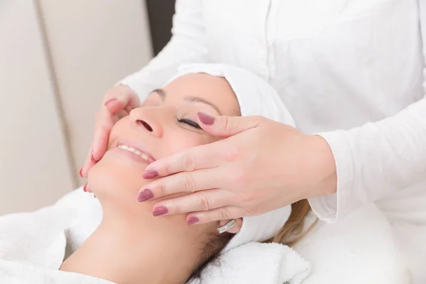 Manos están haciendo un masaje facial — Foto de Stock