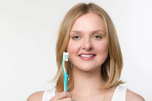 Женщина с зубной щеткой в руке — стоковое фото