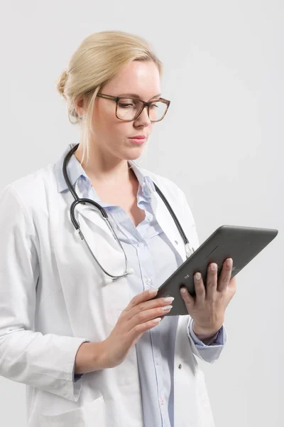 Jovem médico está olhando em um computador pad — Fotografia de Stock