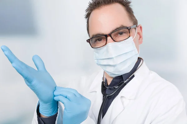 doctor with medical face mask is using medical gloves