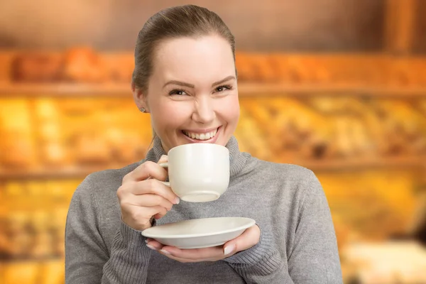 Mujer joven disfruta de una taza de café o té —  Fotos de Stock