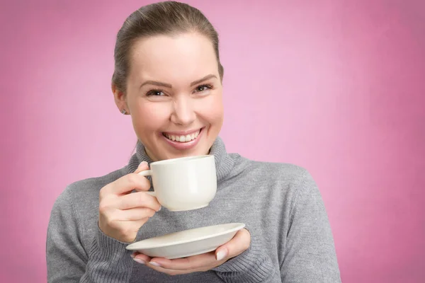 Ung kvinna njuter av en kopp kaffe eller te — Stockfoto