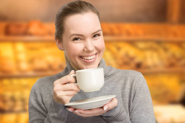 Mujer joven disfruta de una taza de café o té —  Fotos de Stock