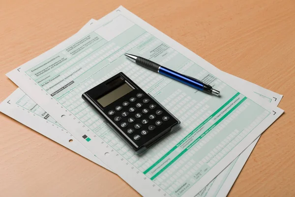 Formulário de declaração fiscal, uma calculadora e uma caneta — Fotografia de Stock