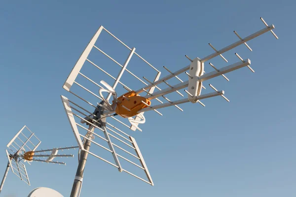 Antena de televisión en una azotea frente al cielo azul — Foto de Stock