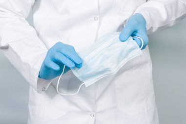 Tıbbi maskeyle doktorun elini kapat.