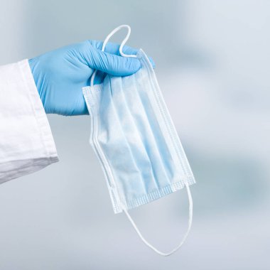Enfeksiyona karşı korunmak için doktorun elini tıbbi maskeyle kapatın.