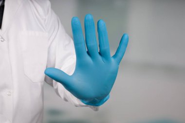 Doktorun elinde tıbbi eldiven var. Karantina bölgesine giriş yok. 