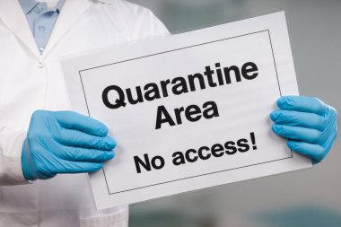 Doktorun elinde tıbbi eldiven var. Yasak bölgenin önünde karantina işareti var.