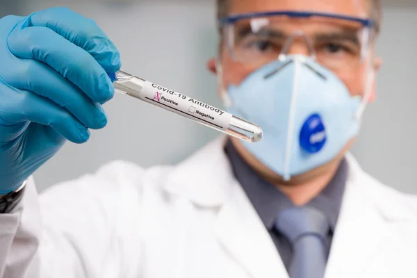과학자나 의사가 마스크를 장갑을 긍정적 결과를 나타내는 표시로 바이러스 시험관을 — 스톡 사진