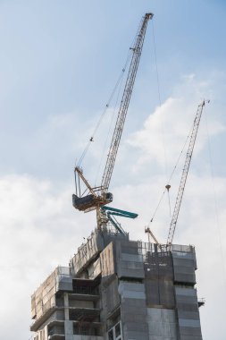 Gökyüzü arka planında vinçleri olan inşaat alanı