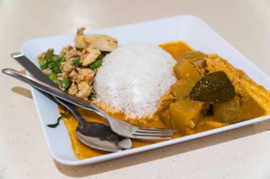 Körili tavuk ve pirinç beyaz bir plaka üzerinde.