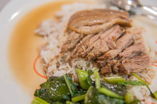 Kaki babi rebus dengan nasi dengan bawang putih dan kale di atas tampilan — Stok Foto