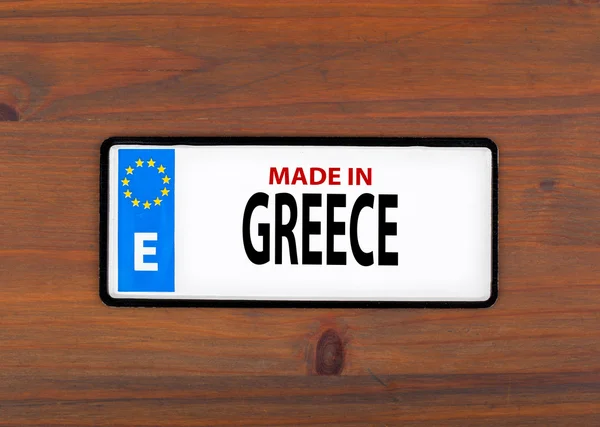 Hecho en Grecia. Sobre una placa metálica de madera con unio europeo — Foto de Stock