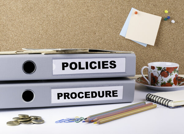 Policies and Procedure - two folders on white office des