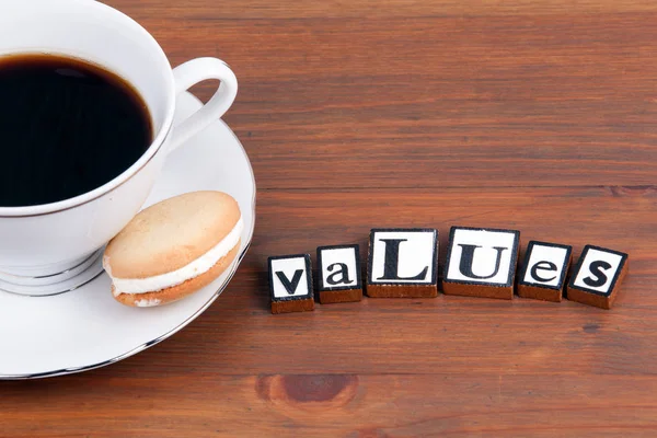 Šálek kávy na dřevěný stůl a text - hodnoty — Stock fotografie