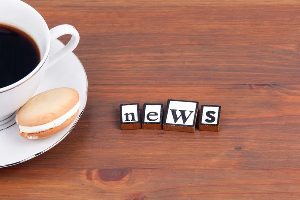Xícara de café em uma mesa de madeira e texto - Notícias — Fotografia de Stock