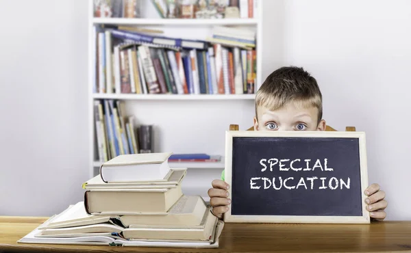 Educación especial. Niño sosteniendo pizarra — Foto de Stock