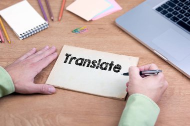Translate yazma el. Bir dizüstü bilgisayar ve Kırtasiye Ofis Masası