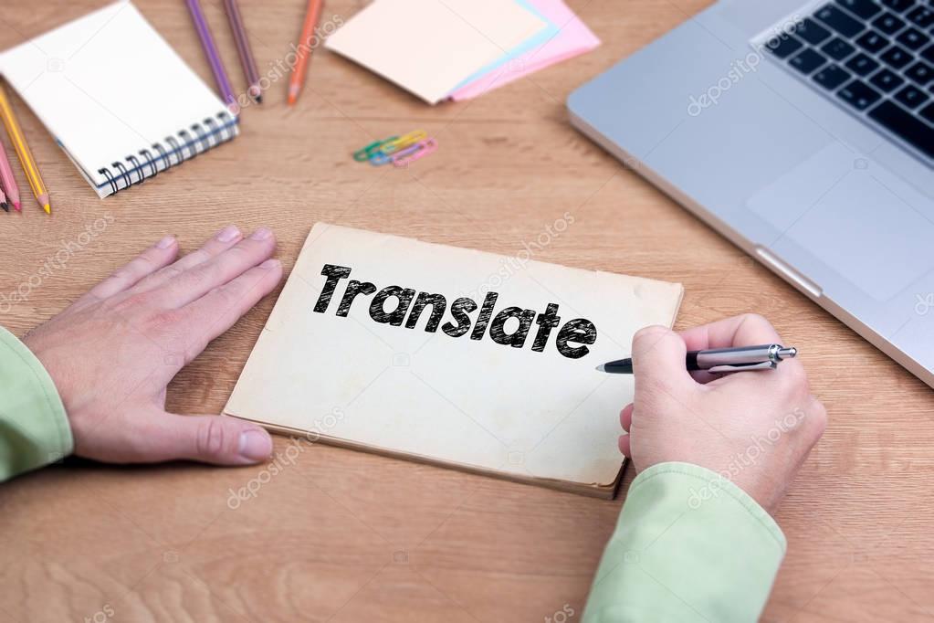 Hand writing Translate. Office desk with a laptop and stationery