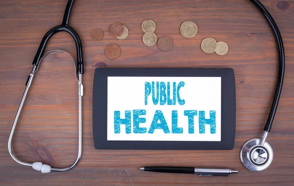 Salud Pública. Dispositivo de tableta en una mesa de madera —  Fotos de Stock