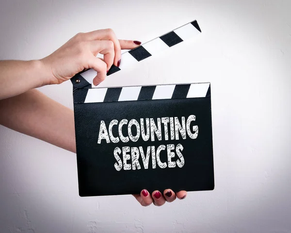 Accounting Services. Female hands holding movie clapper