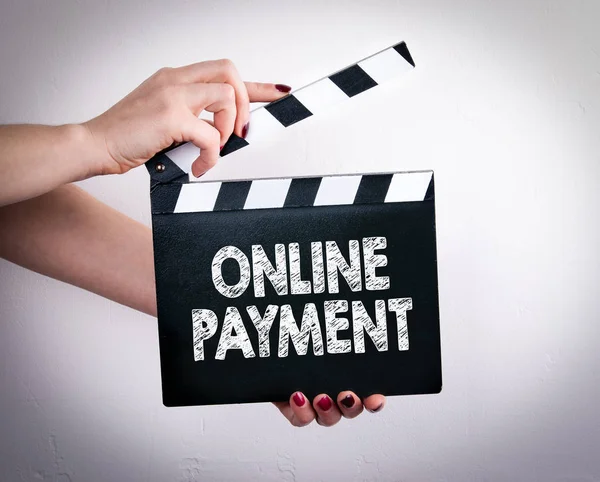 Online Payment. Female hands holding movie clapper