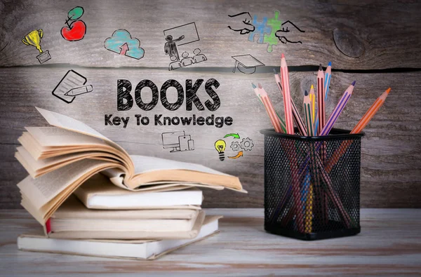 Книги, ключ до знань. Стек книг і олівців на дерев'яному столі . — стокове фото