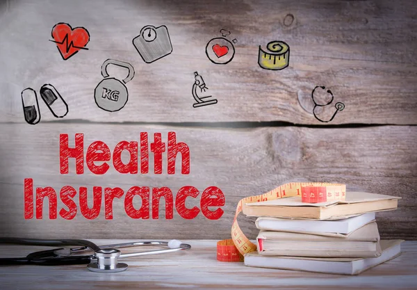 Concetto di assicurazione sanitaria. Pila di libri e uno stetoscopio su uno sfondo di legno — Foto Stock