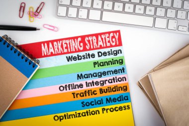 Pazarlama stratejisi kavramı. Ofis Masası ile bir bilgisayar klavye ve renkli sayfalar