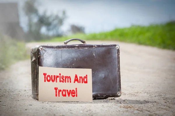 Turismo e viaggi. Vecchia valigia da viaggio su strada di campagna — Foto Stock