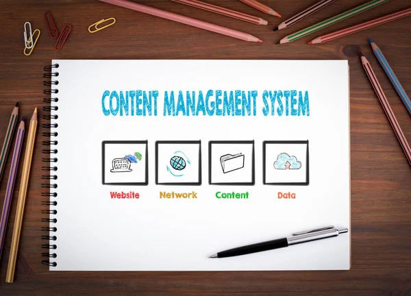 Content Management systému koncept. Poznámkové bloky, pera a barevné tužky na dřevěný stůl — Stock fotografie