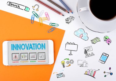 Yenilik kavramı. Cep telefonu ve beyaz ofis masasında kahve fincanı