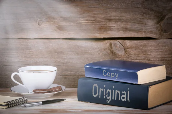 Origineel en kopie. Stapel boeken op houten bureau — Stockfoto