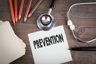 Prevention. Workplace of a doctor. Stethoscope on wooden desk background clipart