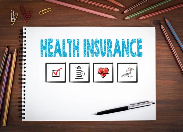 Assicurazione sanitaria. Taccuini, penne e matite colorate su un tavolo di legno — Foto Stock