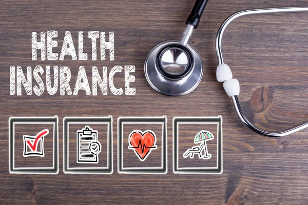 Asuransi Kesehatan. Stetoskop pada latar belakang meja kayu . — Stok Foto