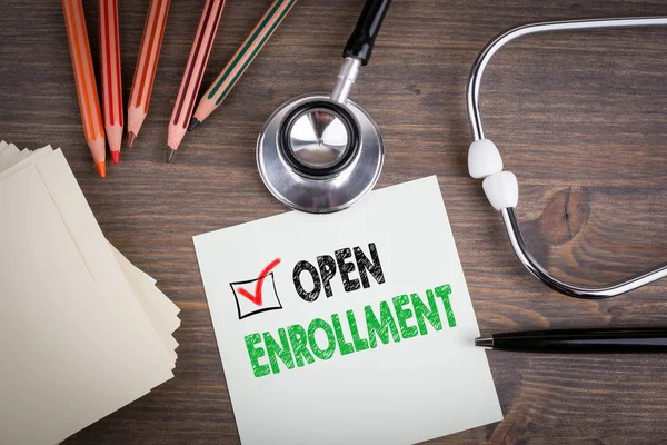 Open Enrollment. Workplace of a doctor. Stethoscope on wooden desk. — Stock Photo, Image