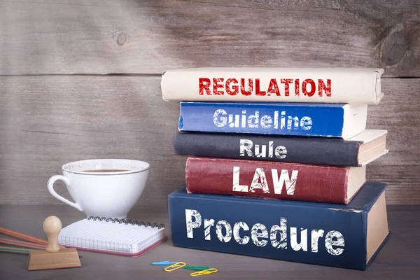Έννοια του κανονισμού. Στοίβα των βιβλίων πάνω στο ξύλινο γραφείο — Φωτογραφία Αρχείου