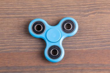 Mavi topluca spinner stres giderici oyuncak ahşap arka plan üzerinde