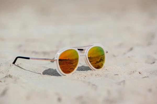 Sunglasses on sandy beach in summer. Vacation background — Stock Photo, Image