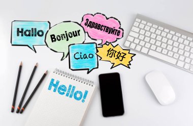 Kelime bulutu dünyanın farklı dilde Merhaba, kavram arka plan. Ofis resepsiyon masası ile bilgisayar, akıllı telefon ve defter