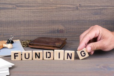 Finansman. Koyu arka plan üzerinde ahşap harfler