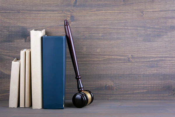 Martelo de madeira e livros no fundo. Conceito de direito e justiça — Fotografia de Stock