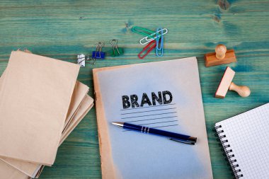 Marka kavramı. Parlak yeşil zemin üzerine not defteri. Ofis Kırtasiye aksesuarları