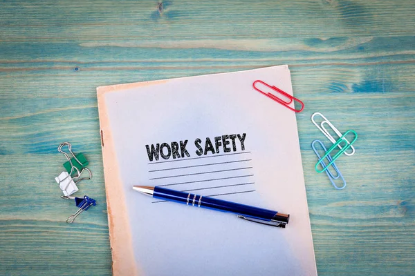 Sikkerhedskoncept på arbejdspladsen. Notesbog på en lysegrøn baggrund. Tilbehør til kontorartikler - Stock-foto