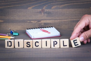 Disciple from wooden letters on wooden background clipart