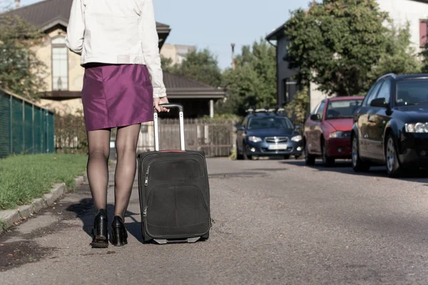Kobieta z torby podróżnej na ulicy, szykując się do jorney — Zdjęcie stockowe