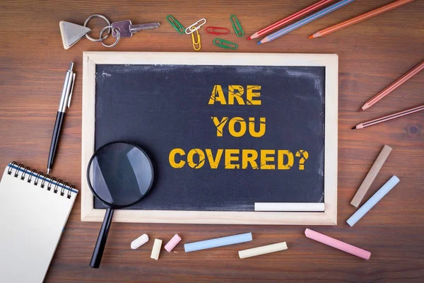 Are You Covered. On a wooden table chalk board