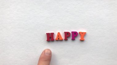 mutsuz. Beyaz bir kağıt üzerine renkli ahşap harfler